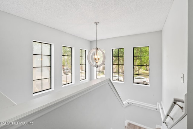 interior space with a wealth of natural light, baseboards, and a textured ceiling