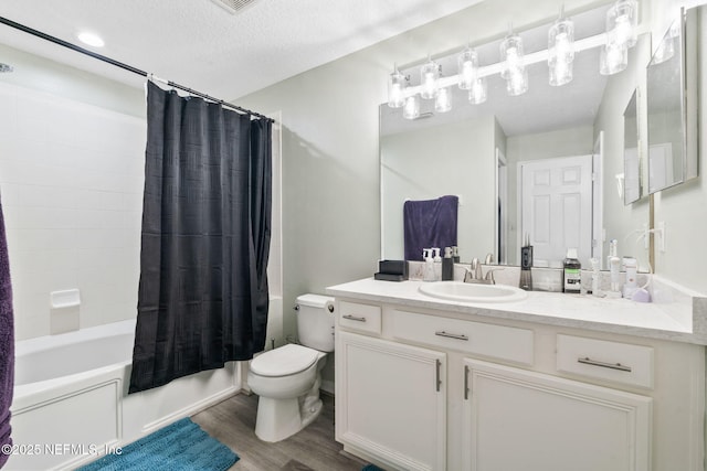 full bath with wood finished floors, toilet, vanity, shower / bath combo with shower curtain, and a textured ceiling