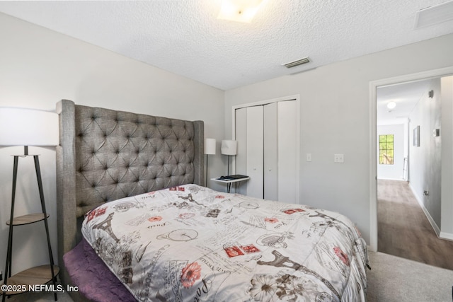 bedroom with visible vents, a textured ceiling, and a closet