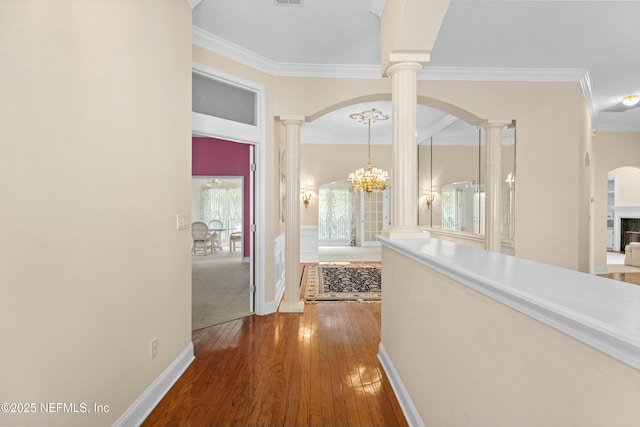 4261 Via Valencia Cir, Jacksonville, FL 32217 - hallway featuring decorative columns, arched walkways, hardwood / wood-style floors, and ornamental molding