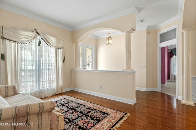 4261 Via Valencia Cir, Jacksonville, FL 32217 - living room featuring ornamental molding, decorative columns, arched walkways, and wood finished floors