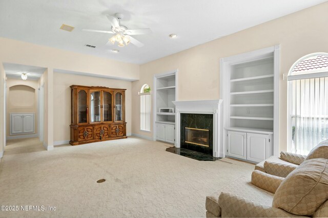 4261 Via Valencia Cir, Jacksonville, FL 32217 - carpeted living area with built in features, ceiling fan, visible vents, a premium fireplace, and baseboards