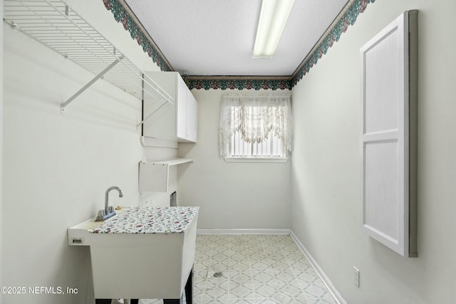 4261 Via Valencia Cir, Jacksonville, FL 32217 - clothes washing area with cabinet space, baseboards, and light floors