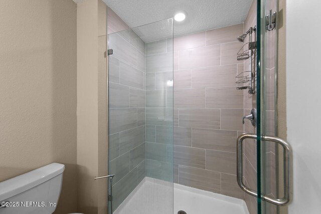 2627 Sandy Dune Dr, Jacksonville, FL 32233 - bathroom with a shower stall, a textured ceiling, and toilet