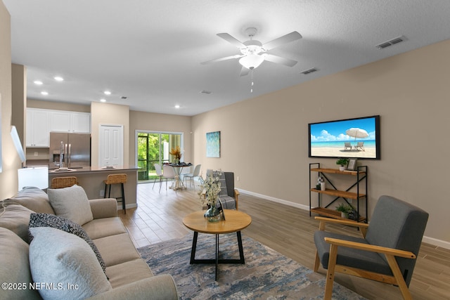 2627 Sandy Dune Dr, Jacksonville, FL 32233 - living room featuring ceiling fan, light wood-type flooring, visible vents, recessed lighting, and baseboards