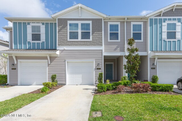 2627 Sandy Dune Dr, Jacksonville, FL 32233 - view of front facade with board and batten siding, an attached garage, and driveway