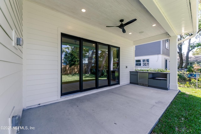 view of patio with ceiling fan and fence