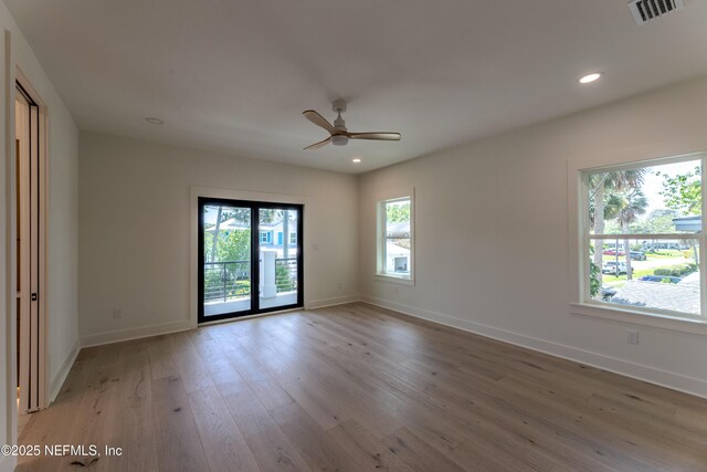 spare room featuring visible vents, baseboards, light wood finished floors, and a ceiling fan