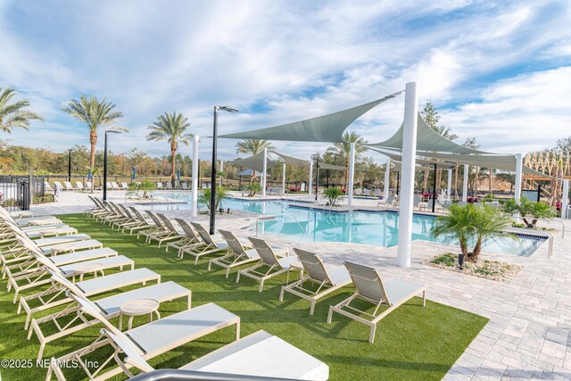 community pool featuring fence, a lawn, and a patio