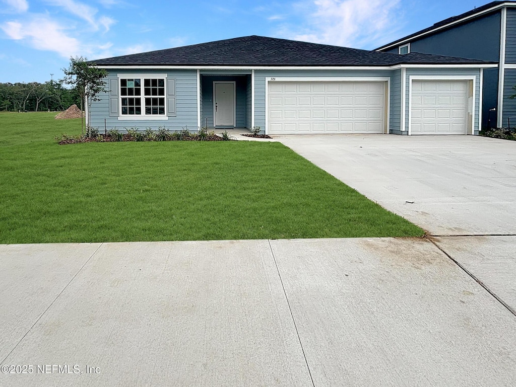 ranch-style home with a garage, a front yard, and concrete driveway