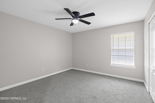 carpeted spare room featuring a textured ceiling, a ceiling fan, and baseboards