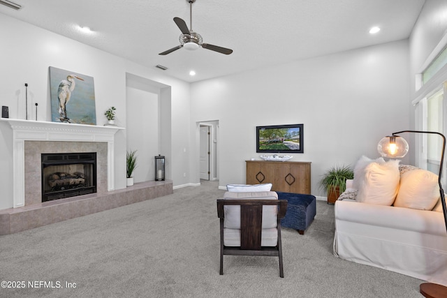 carpeted living room with ceiling fan, a premium fireplace, visible vents, and recessed lighting