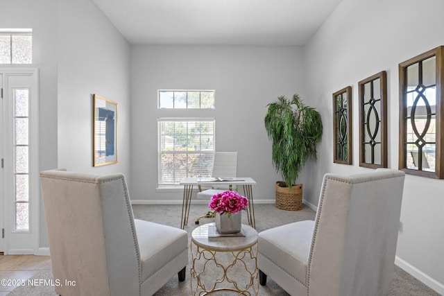 living area with a wealth of natural light, carpet flooring, and baseboards