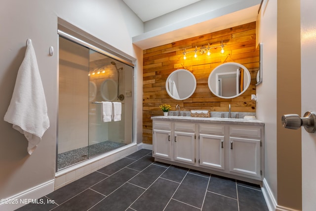 full bath featuring a shower stall, a sink, double vanity, wood walls, and tile patterned flooring