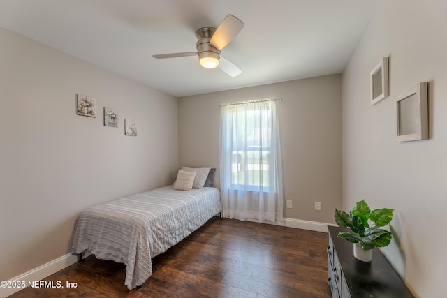 bedroom with baseboards, a ceiling fan, and dark wood-style floors