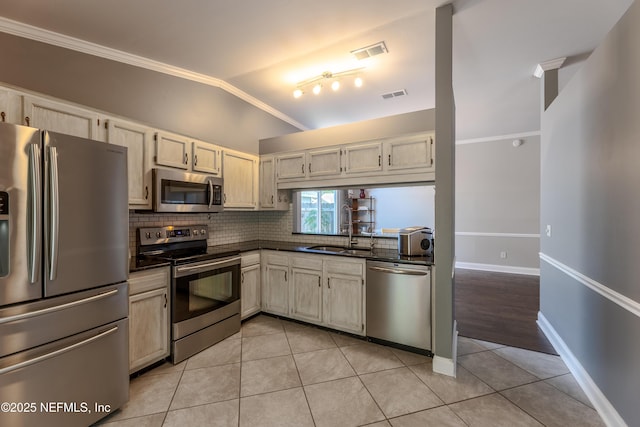 kitchen featuring stainless steel appliances, a sink, visible vents, backsplash, and crown molding