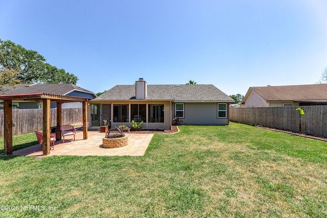 back of house with a fenced backyard, a sunroom, a patio, and an outdoor fire pit