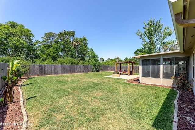 view of yard with a patio area, a sunroom, and a fenced backyard
