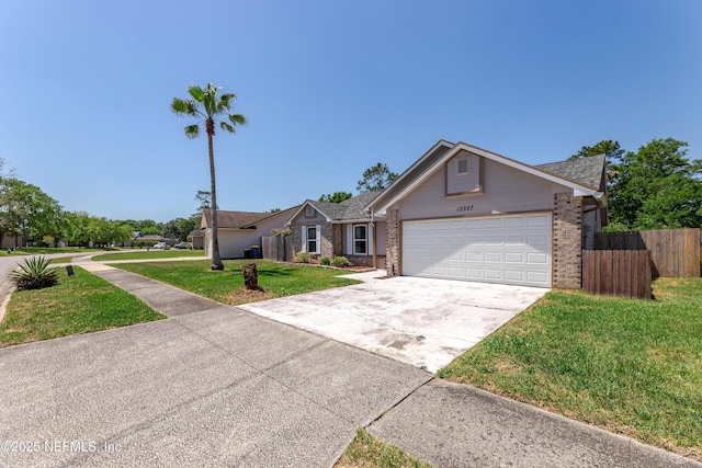 ranch-style home with concrete driveway, fence, brick siding, an attached garage, and a front yard