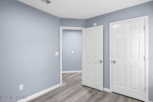11978 Canterwood Dr, Jacksonville, FL 32246 - unfurnished bedroom featuring a textured ceiling, wood finished floors, baseboards, and visible vents