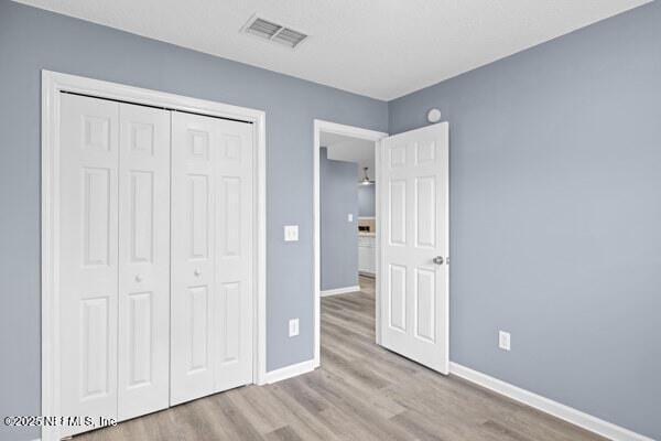 11978 Canterwood Dr, Jacksonville, FL 32246 - unfurnished bedroom with a closet, visible vents, baseboards, and wood finished floors