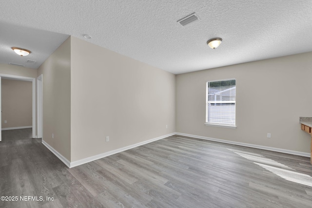 2395 Watermill Dr, Orange Park, FL 32073 - empty room featuring visible vents, a textured ceiling, baseboards, and wood finished floors