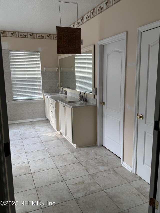 kitchen with plenty of natural light, a sink, and white cabinetry
