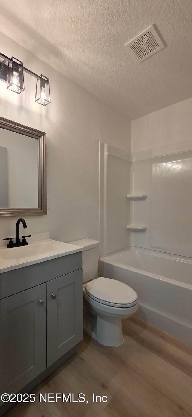 1625 W 27th St, Jacksonville, FL 32209 - bathroom featuring wood finished floors, a textured ceiling, vanity, and shower / bath combination