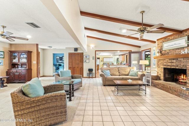 living area featuring a textured ceiling, a fireplace, a ceiling fan, and visible vents