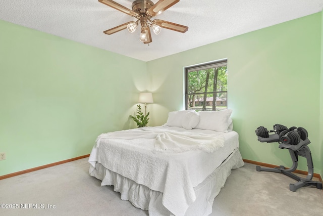 bedroom with a textured ceiling, baseboards, a ceiling fan, and carpet