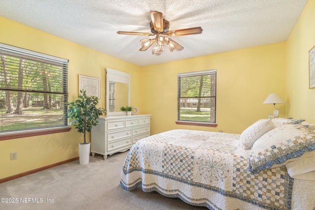 carpeted bedroom with baseboards, a ceiling fan, and a textured ceiling