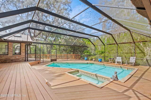 pool featuring a deck, a lanai, and an in ground hot tub