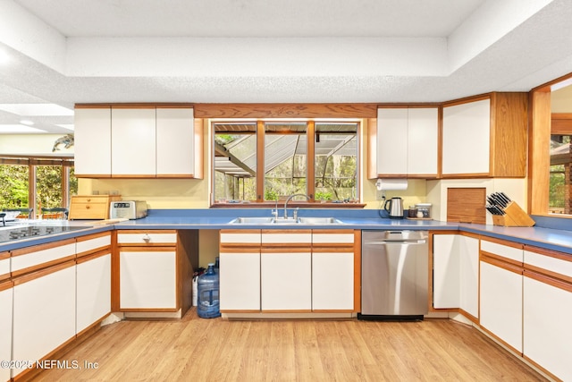 kitchen with light wood-style flooring, white cabinetry, dishwasher, a sink, and black electric stovetop