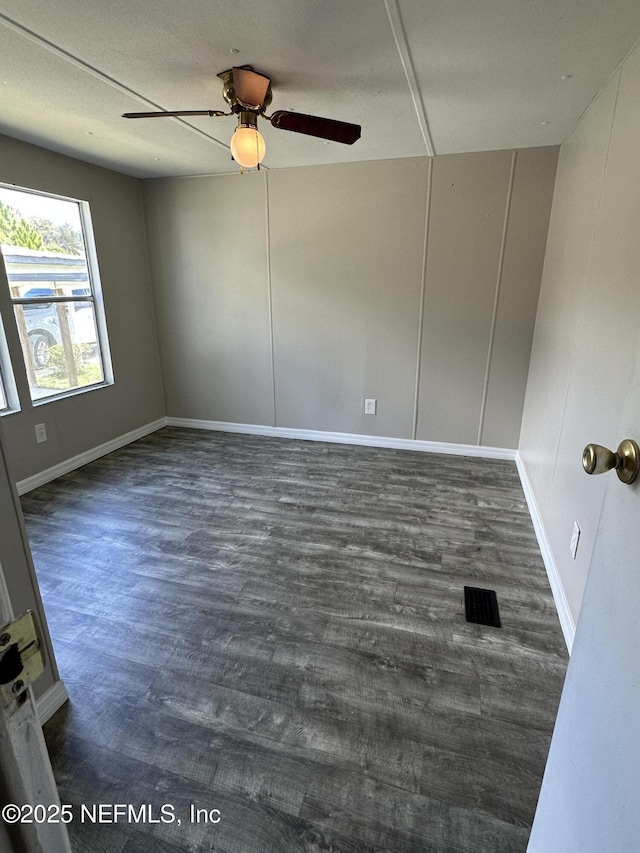 spare room featuring visible vents, baseboards, a ceiling fan, and wood finished floors