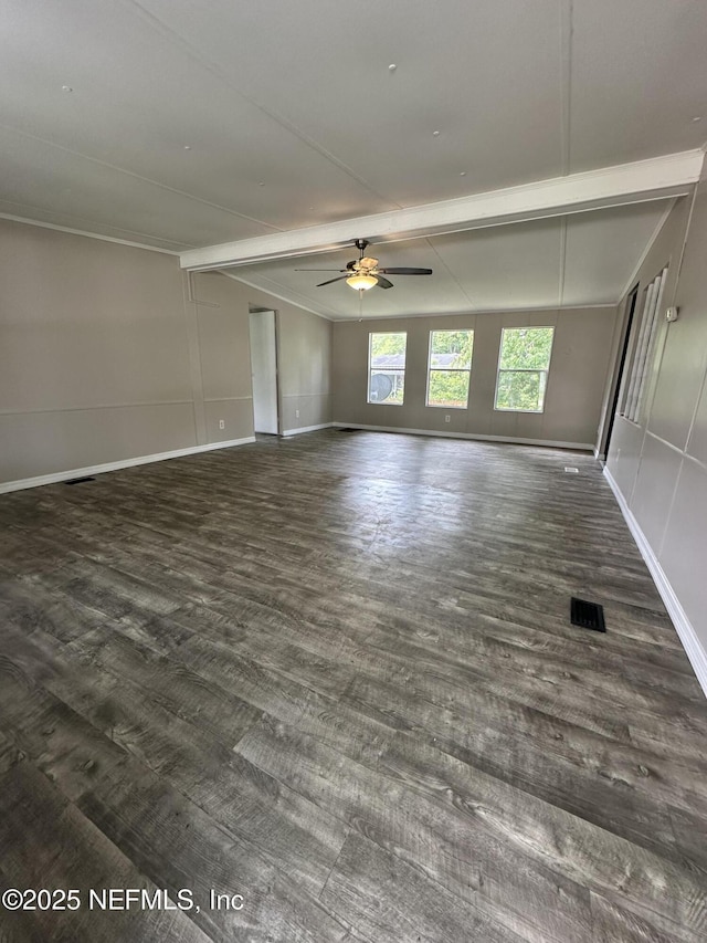 unfurnished room with visible vents, baseboards, a ceiling fan, beamed ceiling, and wood finished floors