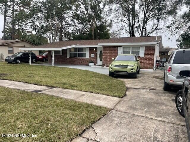 4123 Piper Dr, Jacksonville, FL 32207 - ranch-style house featuring brick siding, driveway, and a front lawn