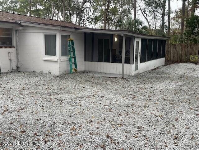 4123 Piper Dr, Jacksonville, FL 32207 - back of property featuring a sunroom, concrete block siding, and fence