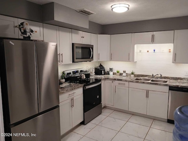 4123 Piper Dr, Jacksonville, FL 32207 - kitchen with a textured ceiling, visible vents, marble finish floor, a sink, and stainless steel appliances