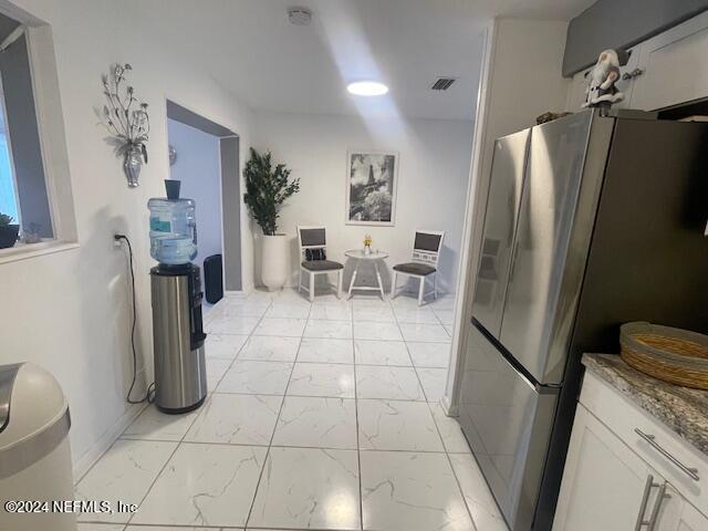 4123 Piper Dr, Jacksonville, FL 32207 - kitchen featuring baseboards, white cabinetry, freestanding refrigerator, visible vents, and marble finish floor