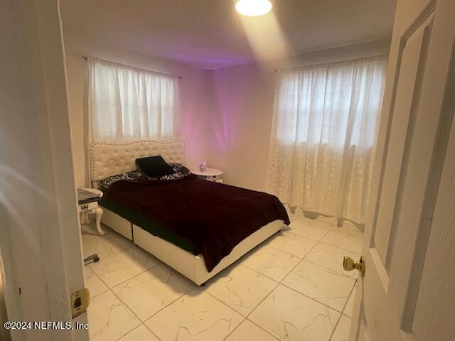 4123 Piper Dr, Jacksonville, FL 32207 - bedroom featuring marble finish floor and multiple windows