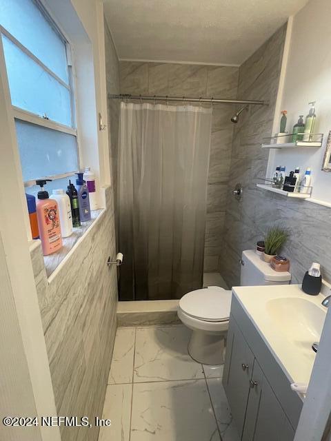 4123 Piper Dr, Jacksonville, FL 32207 - bathroom with a shower stall, vanity, marble finish floor, and toilet