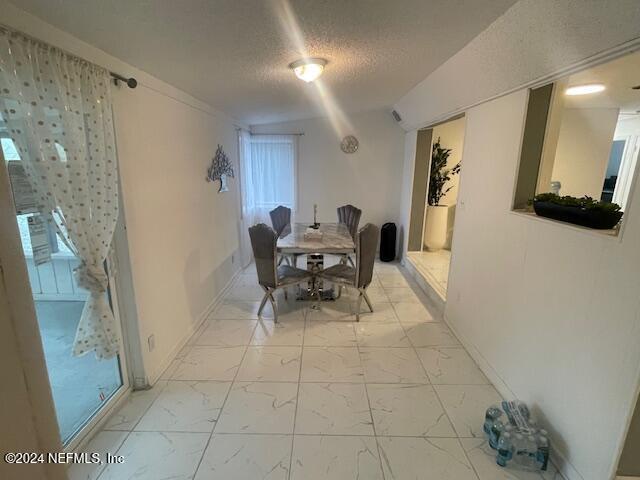 4123 Piper Dr, Jacksonville, FL 32207 - dining room with baseboards, marble finish floor, and a textured ceiling