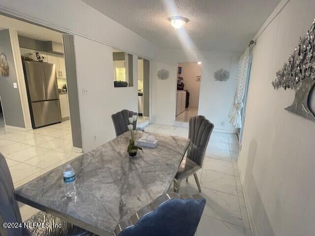 4123 Piper Dr, Jacksonville, FL 32207 - dining space featuring marble finish floor and a textured ceiling
