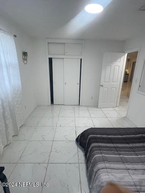 4123 Piper Dr, Jacksonville, FL 32207 - bedroom with a closet, baseboards, marble finish floor, and visible vents