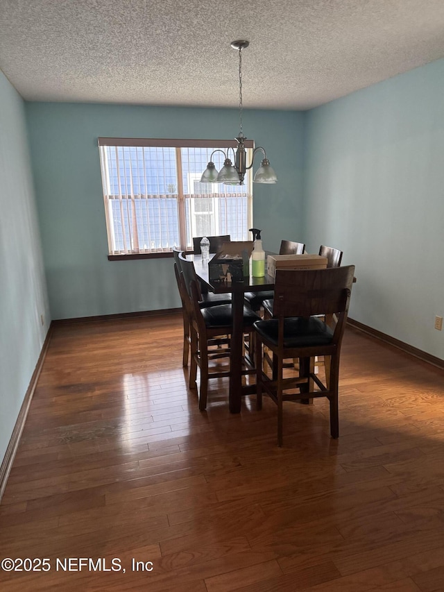 1717 Derringer Rd, Jacksonville, FL 32225 - dining area with dark wood finished floors, baseboards, an inviting chandelier, and a textured ceiling