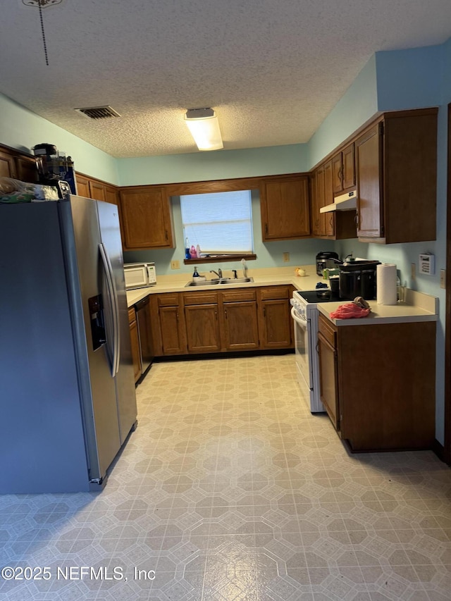 1717 Derringer Rd, Jacksonville, FL 32225 - kitchen featuring light floors, white appliances, under cabinet range hood, and a sink