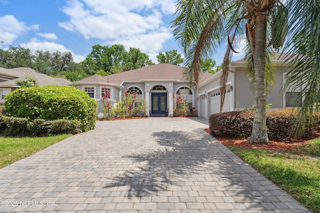 1542 Wescott Loop, Winter Springs, FL 32708 - mediterranean / spanish-style home featuring an attached garage, stucco siding, french doors, and decorative driveway
