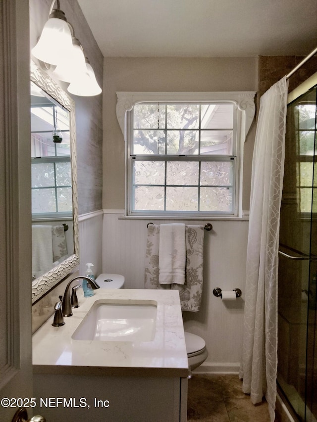512 Clinton Dr, Orange Park, FL 32073 - bathroom featuring toilet, vanity, a shower stall, wainscoting, and tile patterned flooring