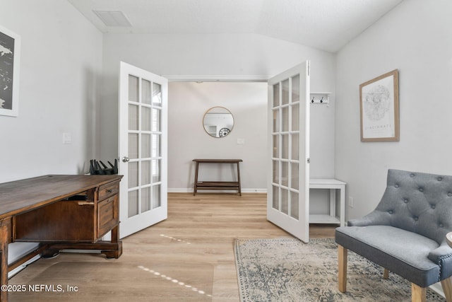 sitting room with visible vents, french doors, wood finished floors, and vaulted ceiling