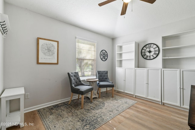 sitting room featuring a textured ceiling, wood finished floors, and a ceiling fan